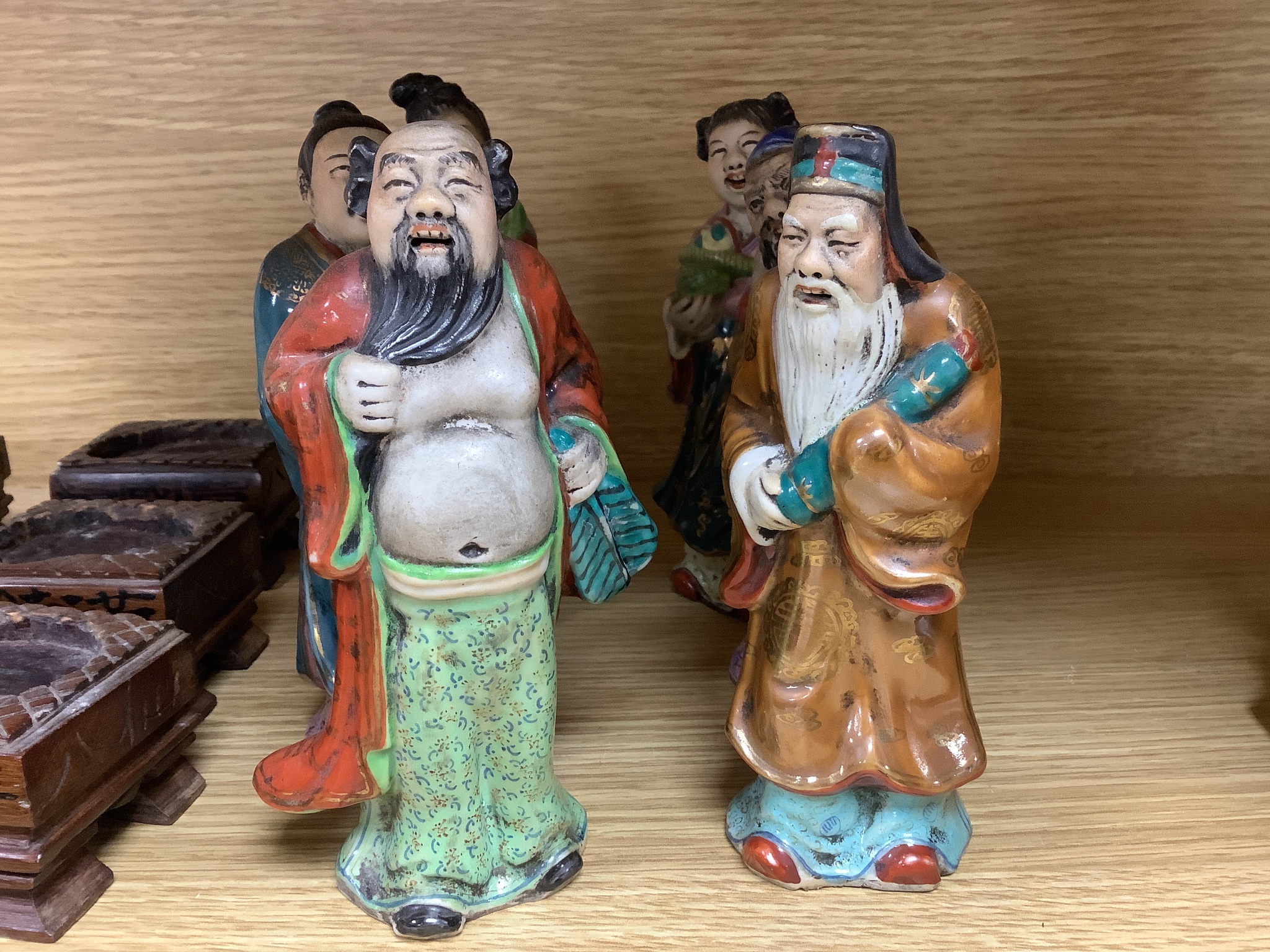 A set of eight 20th century Chinese porcelain figures of immortals, 15cm, each on carved wood stand